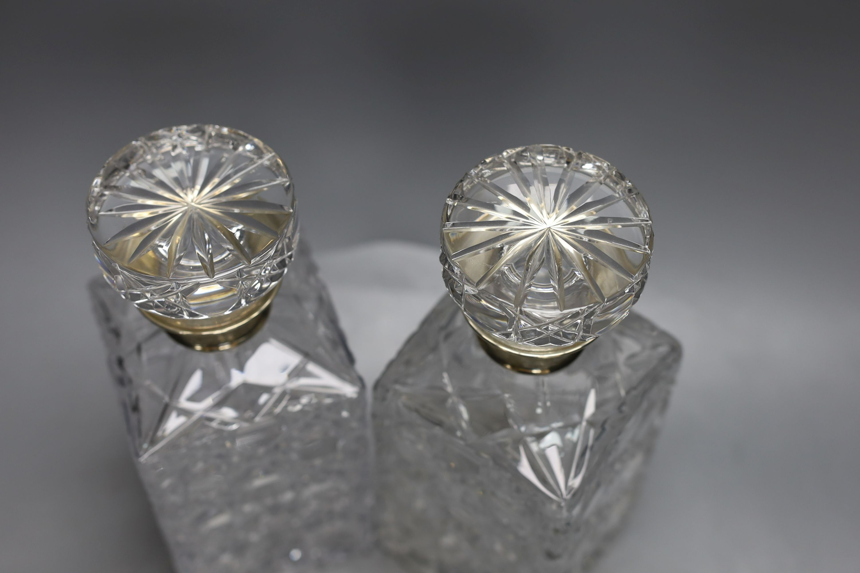 A pair of silver mounted cut glass decanters and stoppers, 23.5cm